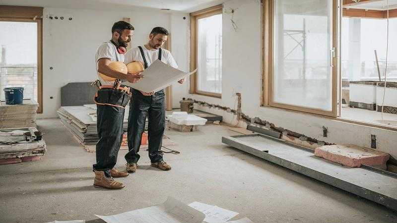 two persons repairing house