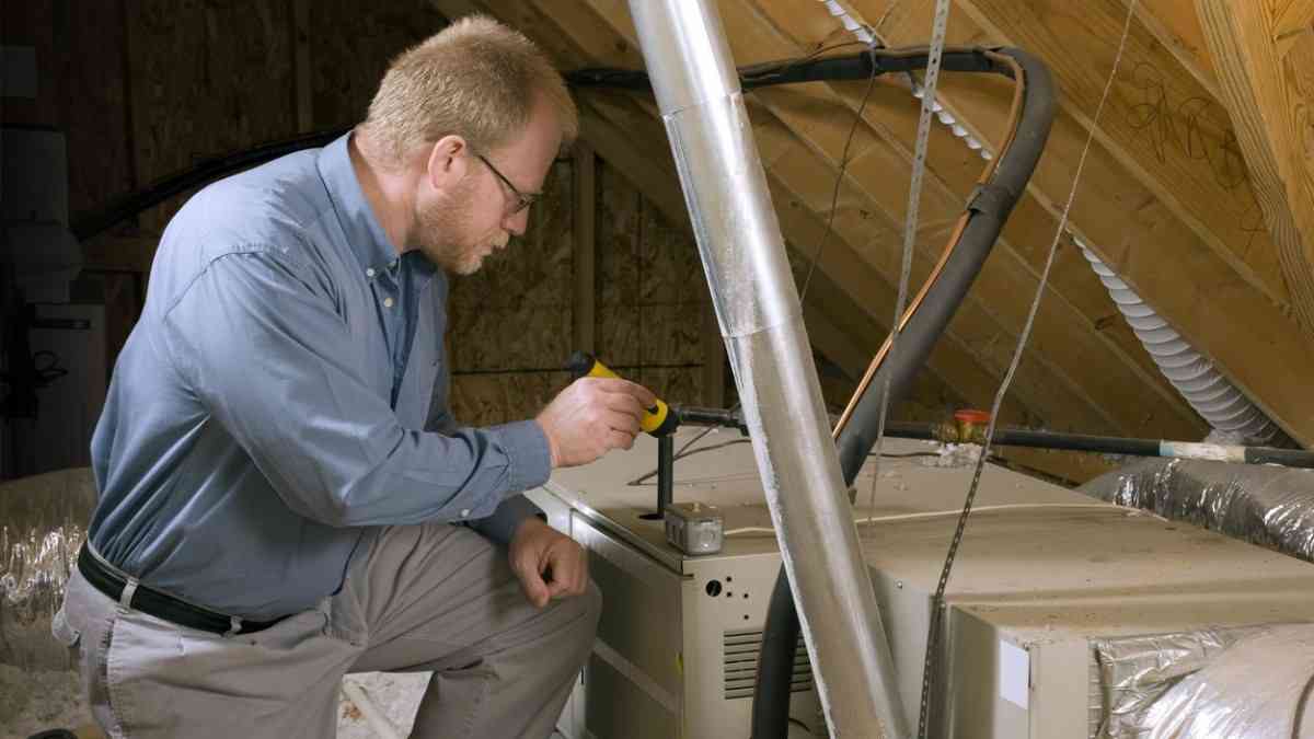 person inspecting house ventilation system