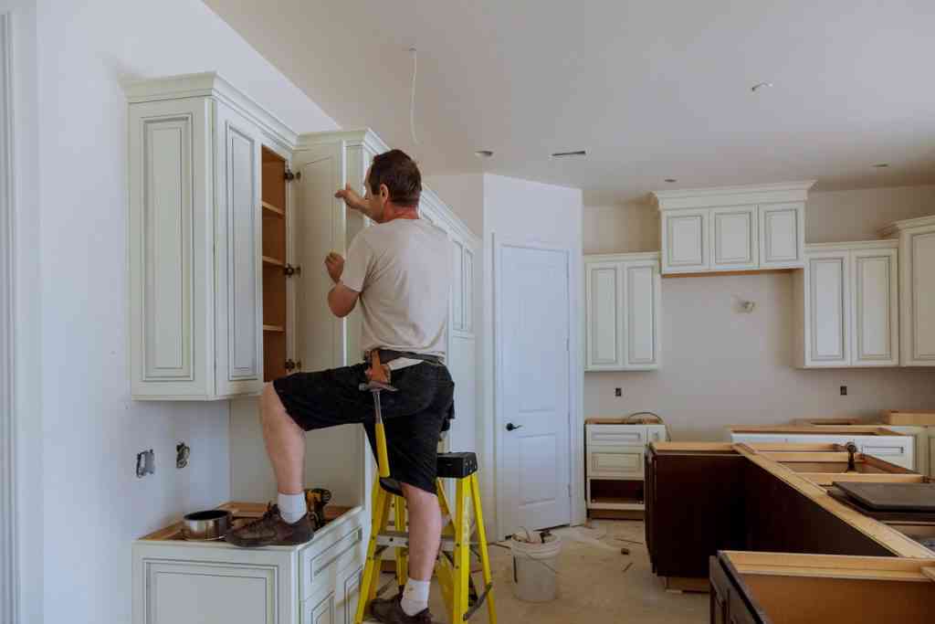 man repairing kitchen cabinet