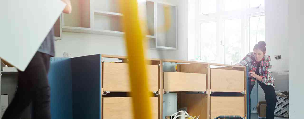 woman fixing cabinet