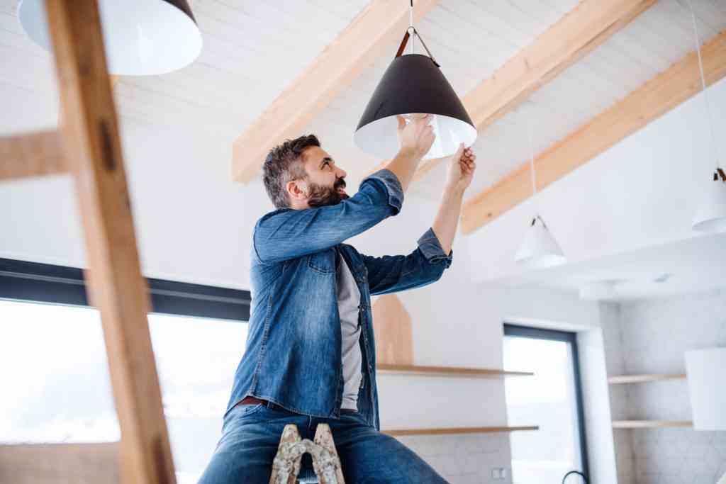 person installing the light bulb in lamp